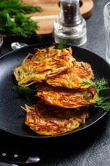 Golden Potato Pancakes with Sour Cream and Fresh Dill on a Dark Table