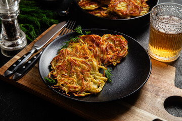Golden Potato Pancakes with Sour Cream and Fresh Dill on a Dark Table