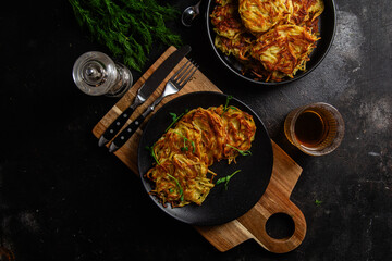 Golden Potato Pancakes with Sour Cream and Fresh Dill on a Dark Table