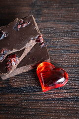 Delicious, dark chocolate with a red heart on a dark background for Valentine's Day