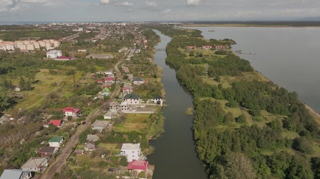 Aerial view flying over coastal town and river