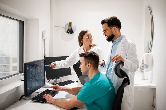 Medical team analyzing ct scan results on computer