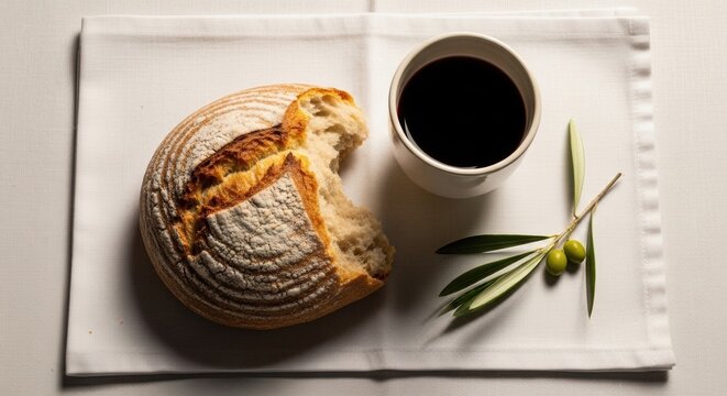 fresh artisan bread with coffee and olive branch on rustic table setting