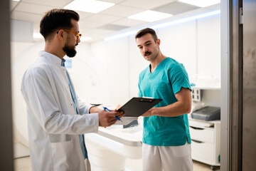 Obraz premium Doctors discussing treatment options in hospital ct scan room