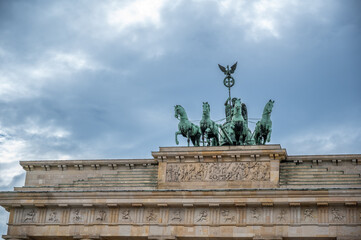 Berlin, germany, august 12, 2023. Brandenburg gate quadriga chariot featuring goddess victoria driving four horses and iron cross on top, iconic berlin landmark