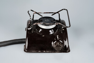 A dark brown single burner electric hot plate is positioned on a light gray surface