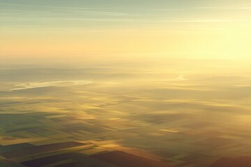 Obraz premium Aerial view of serene landscape at sunrise, showcasing fields and a winding river in the distance