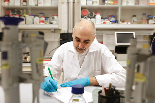 Senior Scientist Writing Notes in a Modern Laboratory