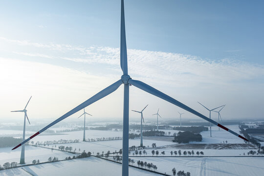 Windenergie - Nahaufnahme von einem Windrad aus der Vogelperspektive in winterlicher Landschaft.