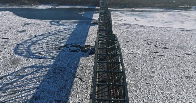 Bridge with traffic over a frozen river with ice floes.