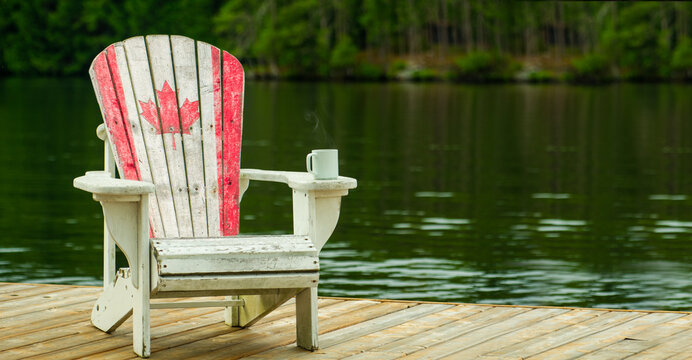 White Adirondack chair with a Canadian maple leaf on a Muskoka dock. Steaming coffee mug on armrest with a calm lake and forest background. Includes ample copy space for brand overlays.