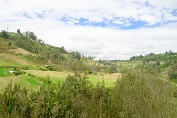 Fototapeta premium Ipiales Green hilly rural landscape with scattered houses and farmland