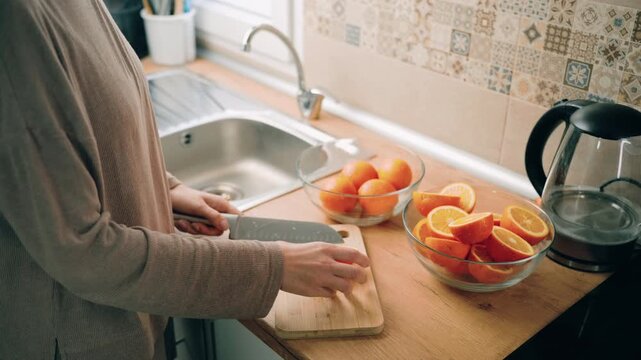 Making fresh orange juice as a healthy vitamin drink at home. Female hands prepare citrus juice from scratch. Nutrition, immunity support, natural lifestyle and clean eating concept.