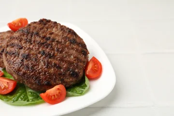 Fotobehang Eten Delicious grilled meat patties, tomatoes and spinach on white tiled table, closeup. Space for text  © New Africa