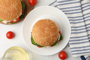 Obraz premium Delicious burgers with meat patties on white table, flat lay