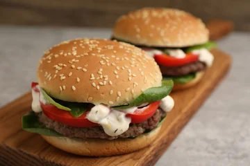 Fotobehang Eten Delicious burgers with meat patties on grey table, closeup  © New Africa