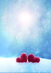 Happy valentines day background with two red hearts on white snow .