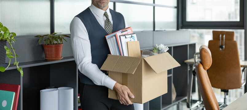 Losing his job. Jobless man unemployed. Career failure. Businessman leaving office holding box with office supplies. Sad fired businessman being dismissed. Unemployed manager with box, cropped view