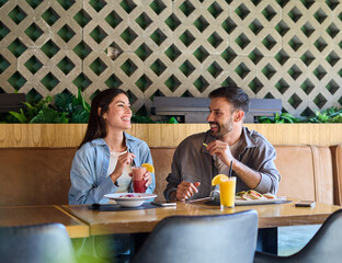 Portrait of ayoung romantic couple in restaurant having lunch