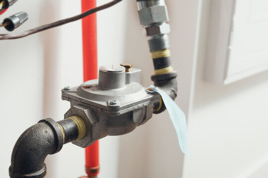 Vent-limiter or gas pressure regulator for natural gas heating in home. Gas system safety device to limit gas flow if the regulator diaphragm fails. Indoor installation. Selective focus.