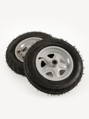 Two wheels from a garden cart on a white background.