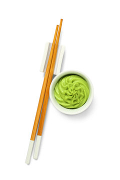Bowl of tasty wasabi with chopsticks on white background