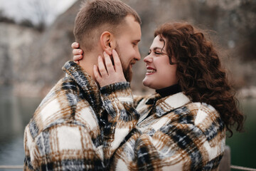 Fototapeta premium A couple sharing a moment together by the water on Valentines Day while wearing matching outfits in winter