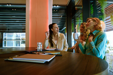 Obraz premium Group of colleagues in a modern workspace enjoying casual conversation and collaboration