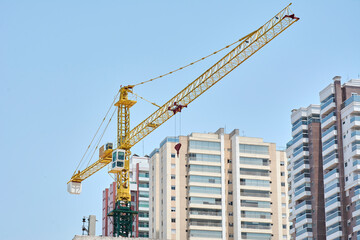 Fototapeta premium Tower crane over modern residential buildings.