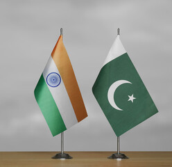 Two table flags of India and Pakistan on a blurred gray background