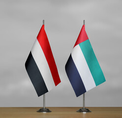 Two table flags of Yemen and Emirates on a blurred gray background
