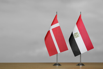 Two table flags of Denmark and Egypt on a blurred gray background