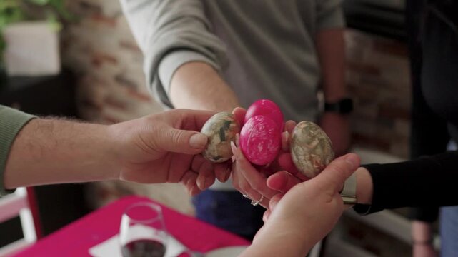 People celebrating easter with dyed eggs, a festive holiday tradition with family gathering and tapping painted eggs
