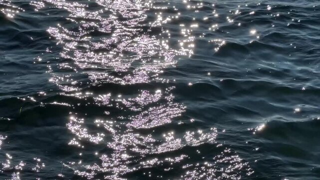 gentle sea waves with glistening sun on water