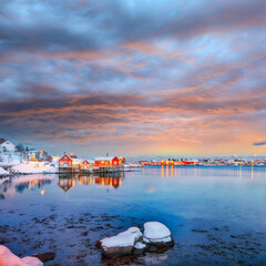 Naklejka premium Outstanding evening cityscape of Reine town. Red rorbuers on the shoore of Reinefjorden.