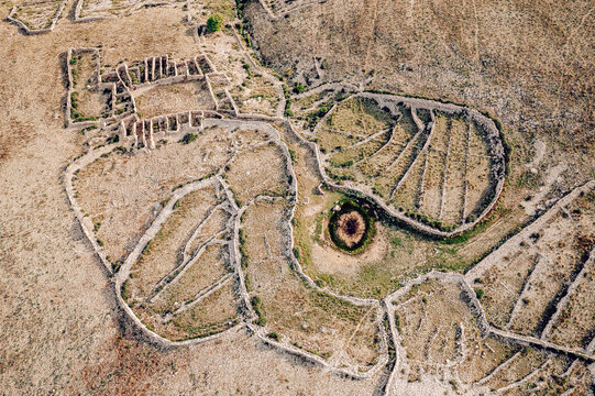 Aerial view of ancient stone walls and agricultural terraces etched into the arid landscape, creating a textured mosaic under the Croatian sun, Baska, Primorje-Gorski Kotar County, Croatia.