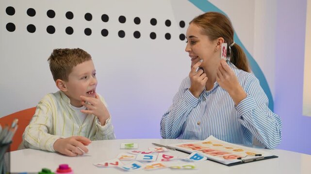 Speech therapist working on pronunciation with a young boy