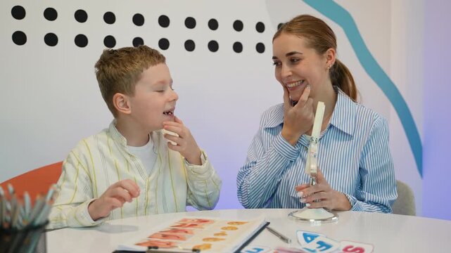 Speech therapist working with young boy on articulation