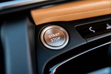 Car interior with illuminated start stop button set in textured leather dashboard, signaling readiness for urban commute or road trip.
