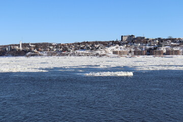 Obraz premium A riverside in winter and the Quebec city area. The south coastline of Quebec city and the area of Levy. Architecture and riverside of Levy in winter with the St-Laurent river in January.