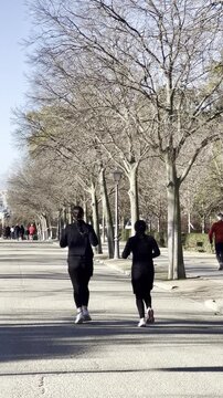 Dos mujeres runner corriendo por el parque haciendo footing y jogging para estar en forma y adelgazar