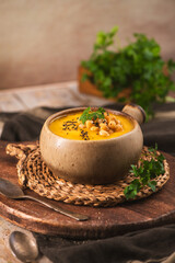 Creamy Pumpkin Soup with Chickpeas and Black Cumin in a Rustic Ceramic Bowl