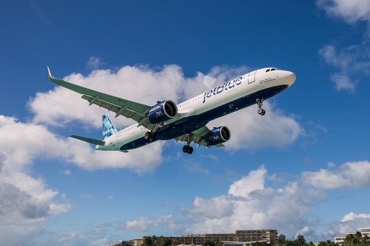 ST MARTIN, ANTILLES &ndash; JAN 23, 2026: Passenger jet airplane of JetBlue airlines taking off or landing against bright blue sky with scattered clouds
