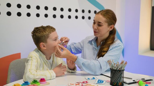 Speech therapist working on articulation with young boy