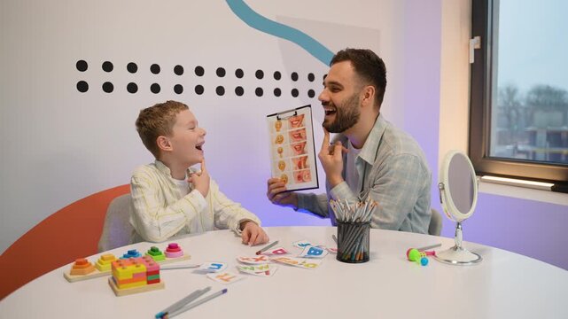 Male speech therapist teaching boy articulation