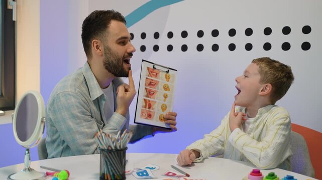 Male speech therapist teaching child articulation exercises
