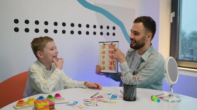 Male speech therapist teaching articulation to young boy