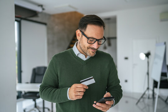 Man using smart phone and credit card for online shopping