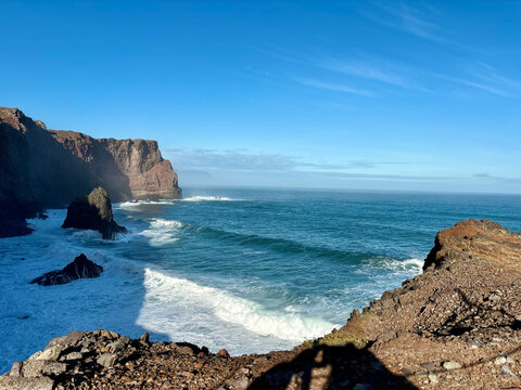 Ocean waves, mountains and blue sky in Canical area of Machico, Madeira, Portugal