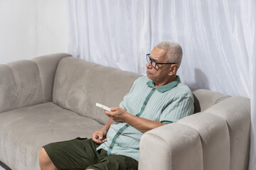 Fototapeta premium Routines senior man relaxing at home watching tv